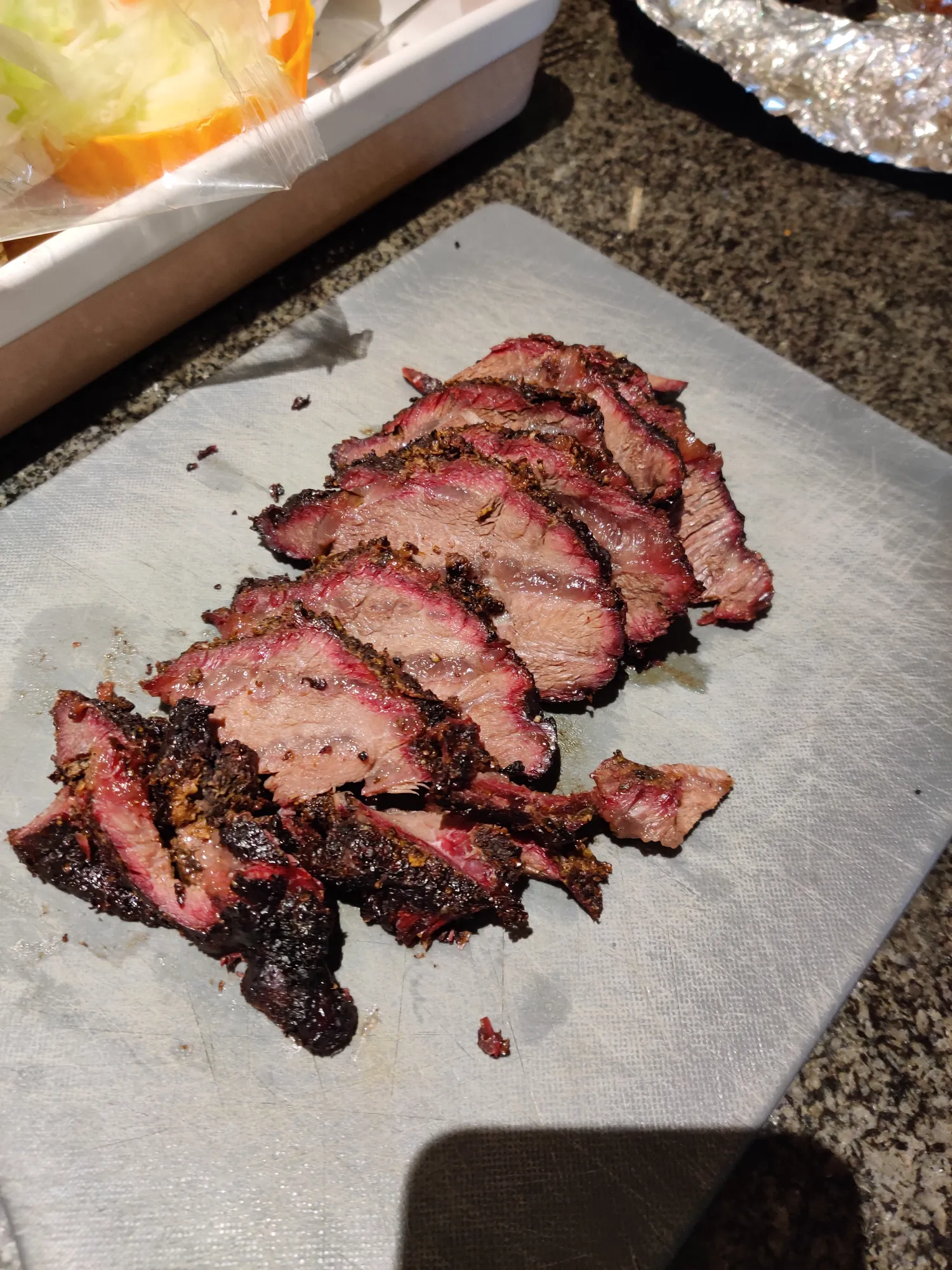 Beef cheeks van de BBQ — donkere bark, aansnijden op snijpapier