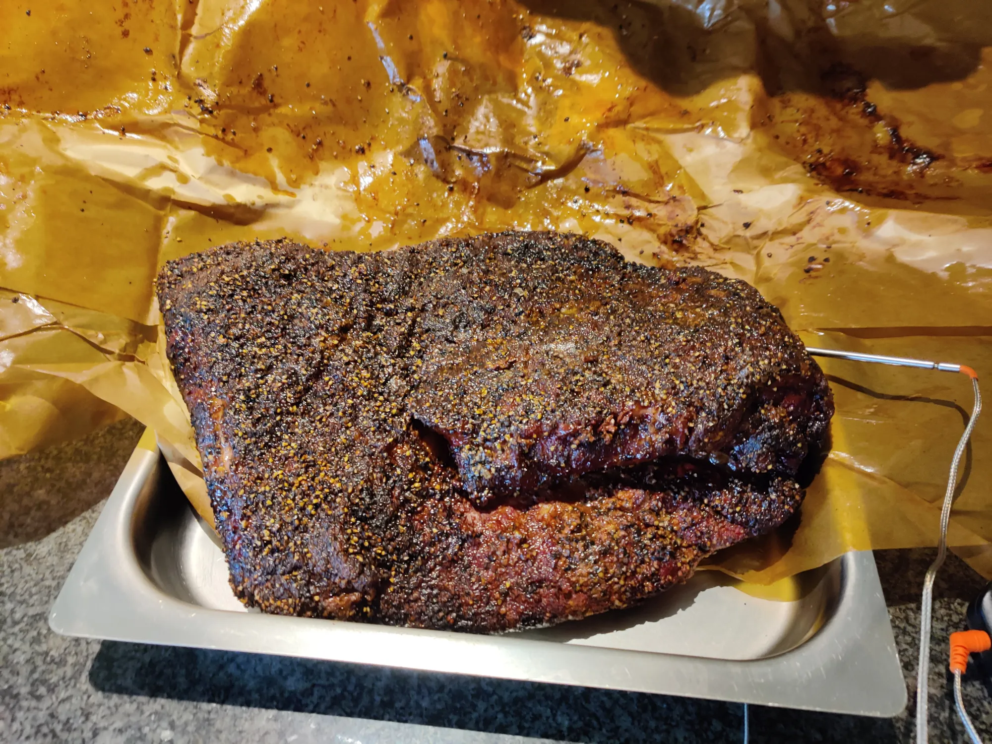 Brisket met donkere bark ingepakt in butcher paper — rustfase