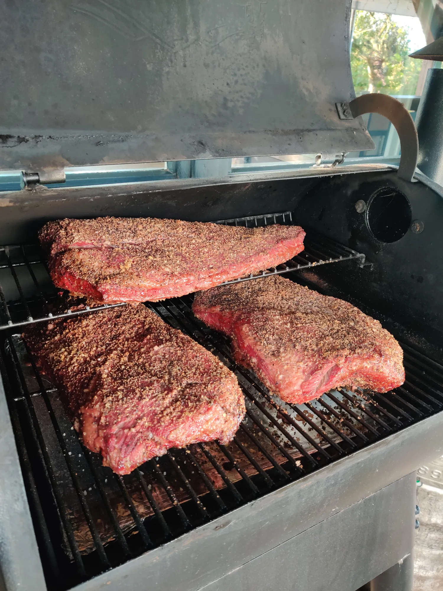 Drie briskets met rub op de smoker — garen tot de stall