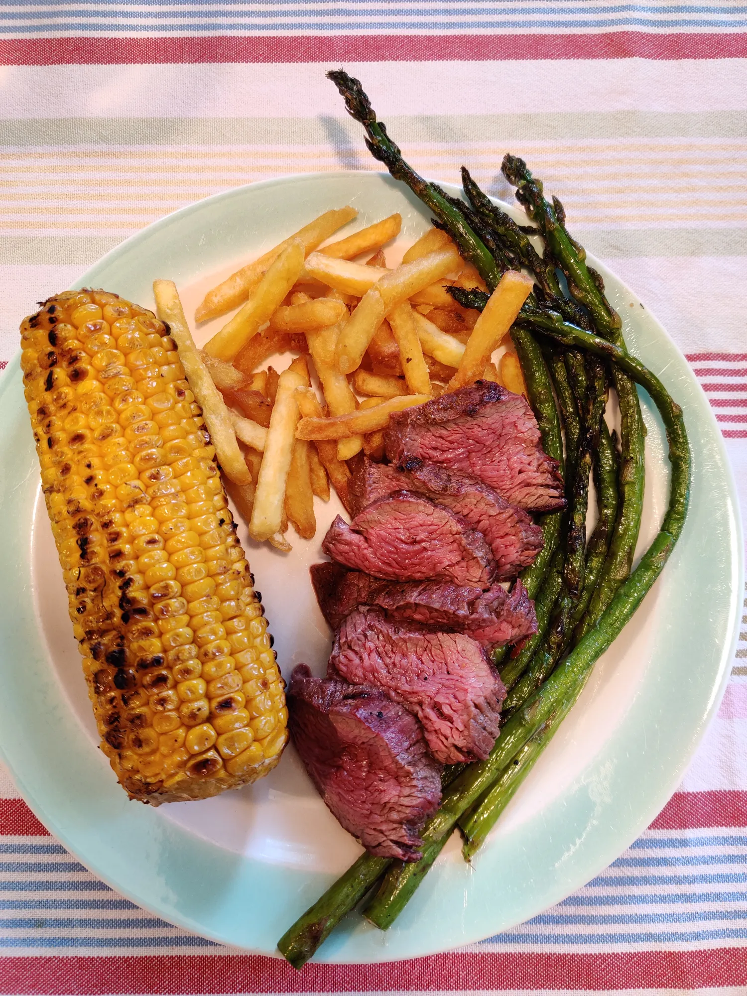 Diamanthaas geserveerd op bord met gegrilde mais, friet en asperges