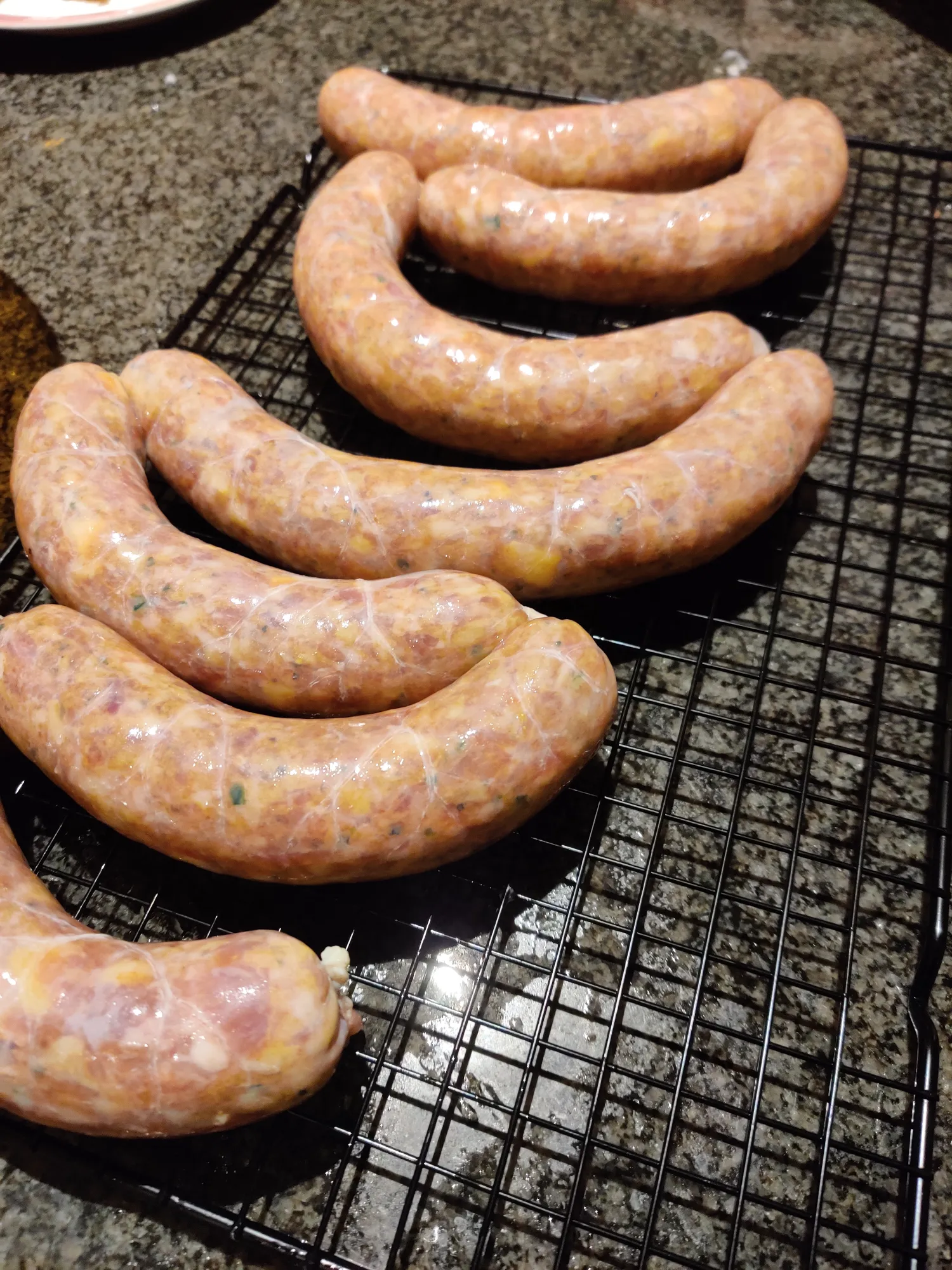 Verse jalapeño worsten op rek na het vullen en draaien